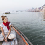 Western woman on a boat exploring the River Ganges