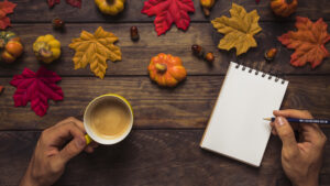 man-writing-autumn-decorated-workplace